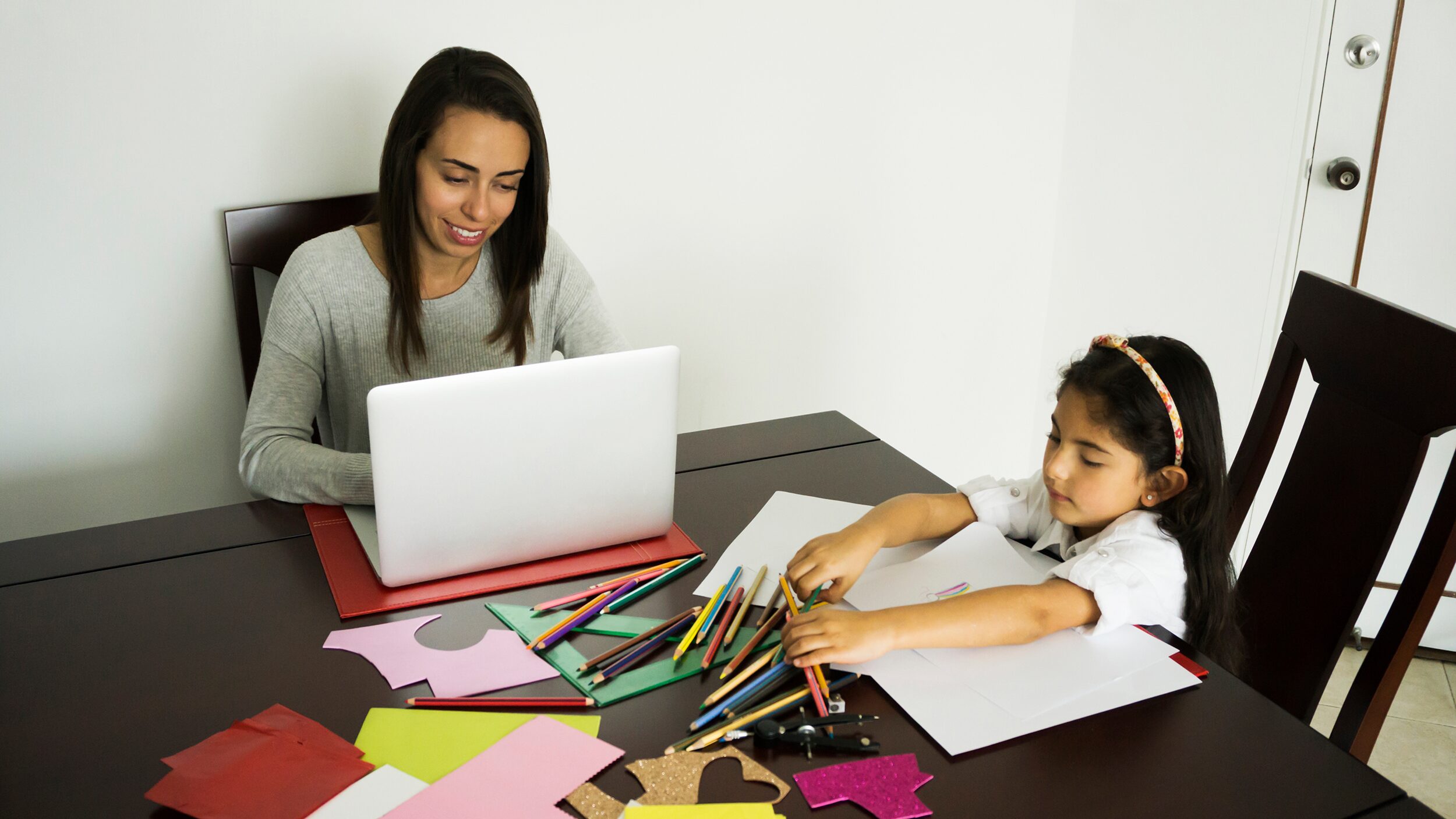 Woman working from home with her kid.